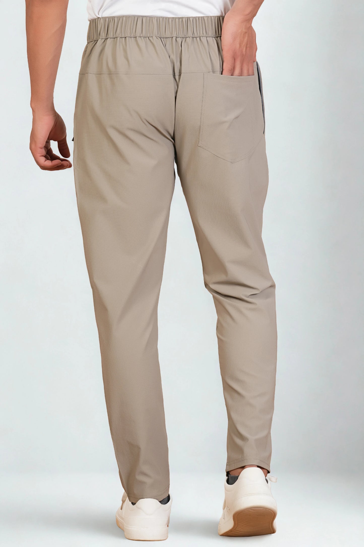 Beige pants worn by a person on a white background