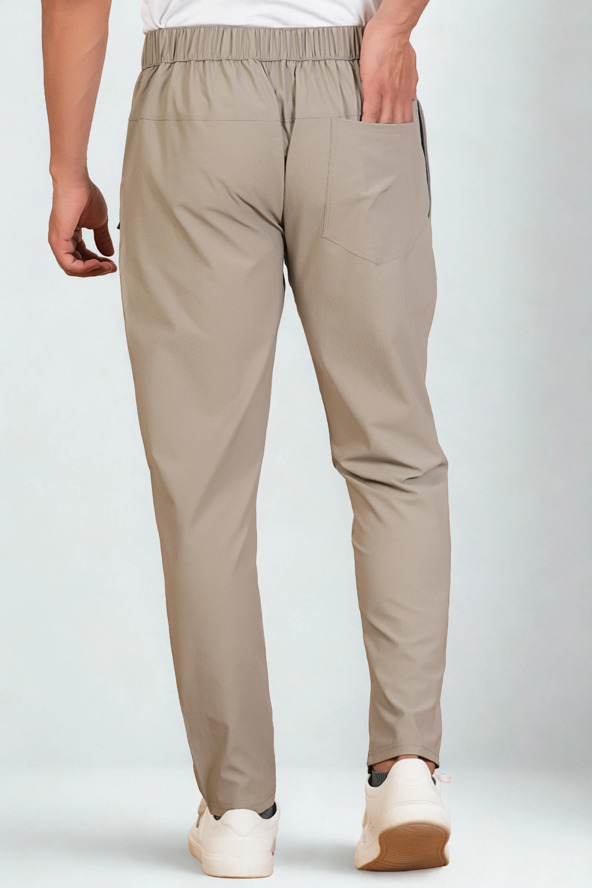 Beige pants worn by a person on a white background