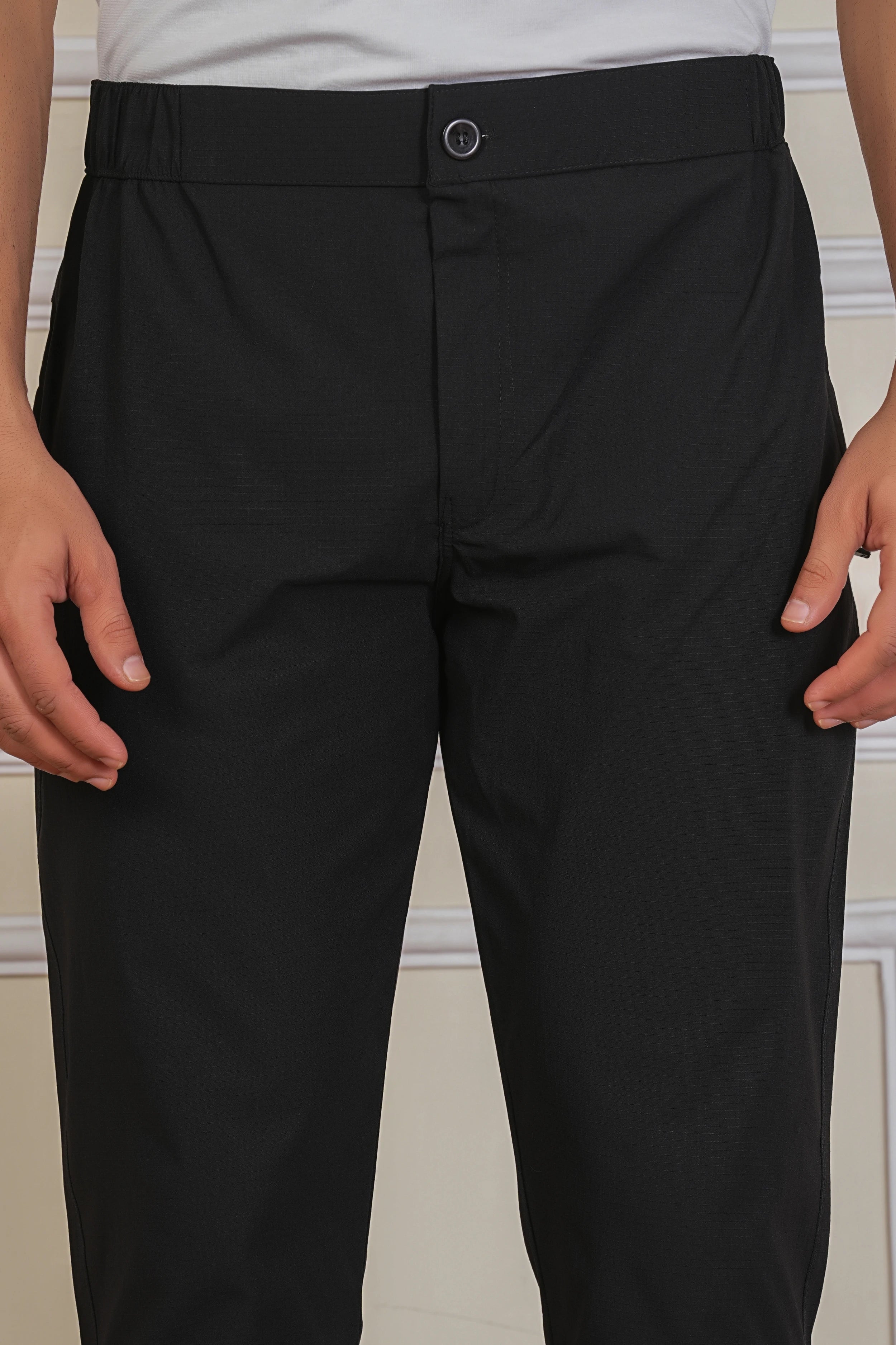 Black button trackpant fabric close-up showing soft breathable material