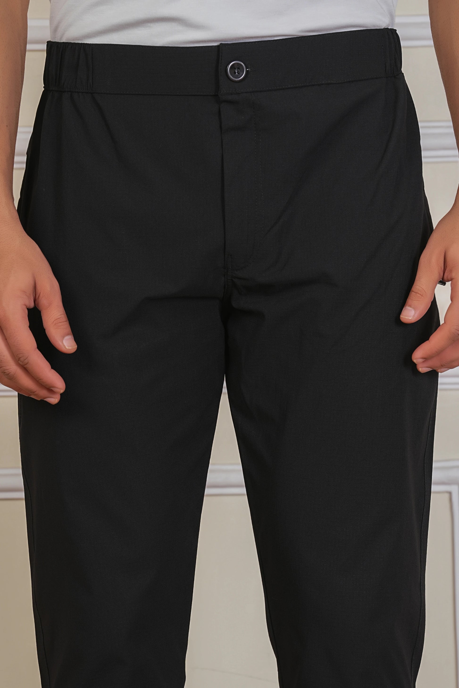 Black button trackpant fabric close-up showing soft breathable material
