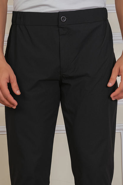 Black button trackpant fabric close-up showing soft breathable material