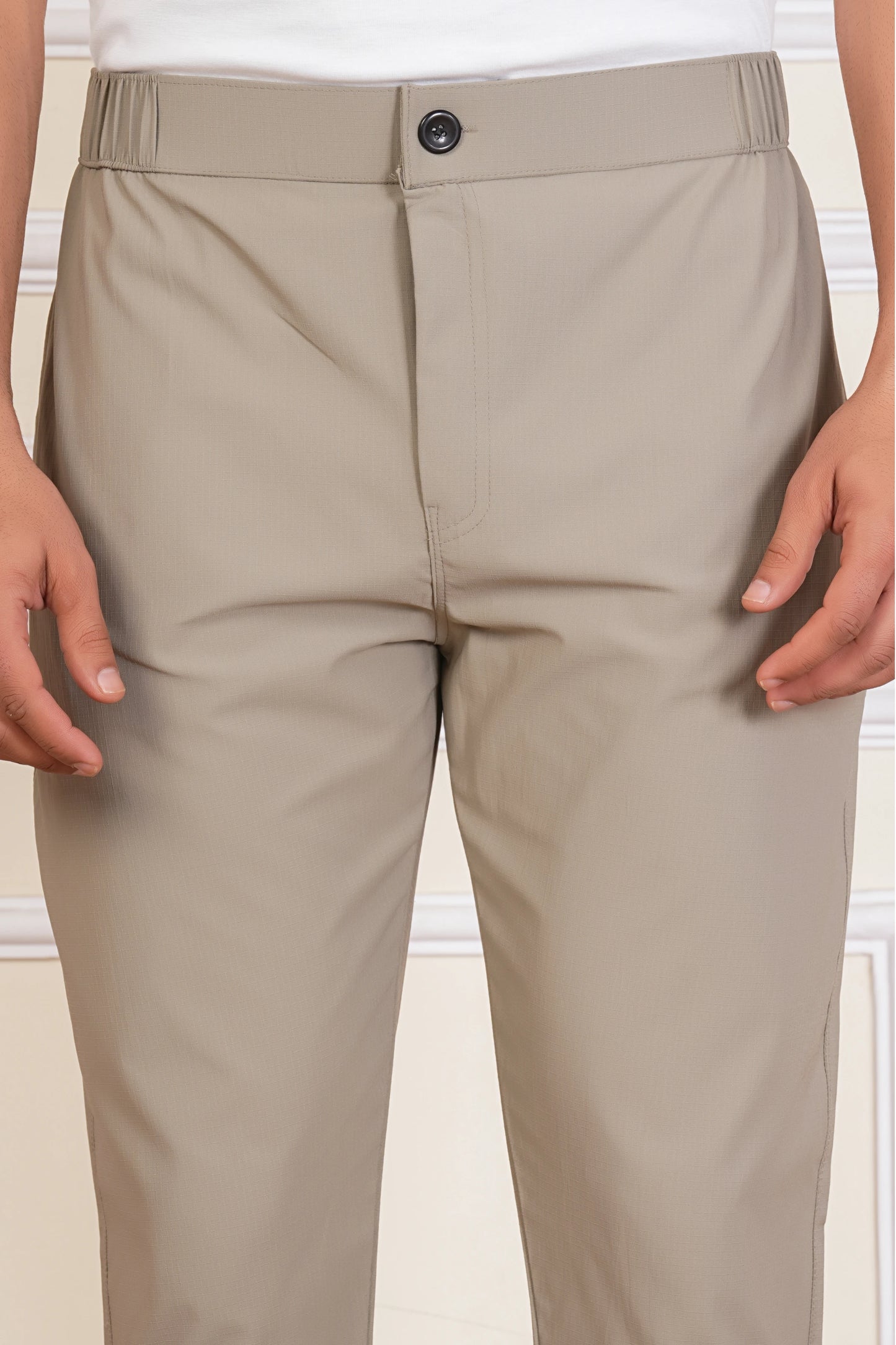 Beige pants worn by a person on a plain background